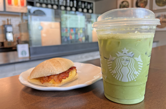 Matcha beverage and a breakfast sandwich with egg and bacon