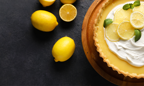 Lemons and lemon cream pie on a black background