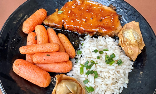 Teriyaki glazed pork loin, bistro baby carrots, garlic buttered rice, pork wontons and Thai chili sauce