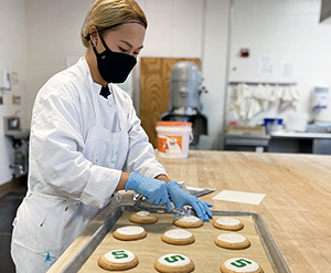 MSU Bakers decorator making game day cookies